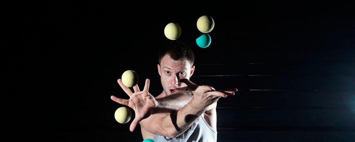 Man juggling too many balls at once, alluding to overloaded span of control